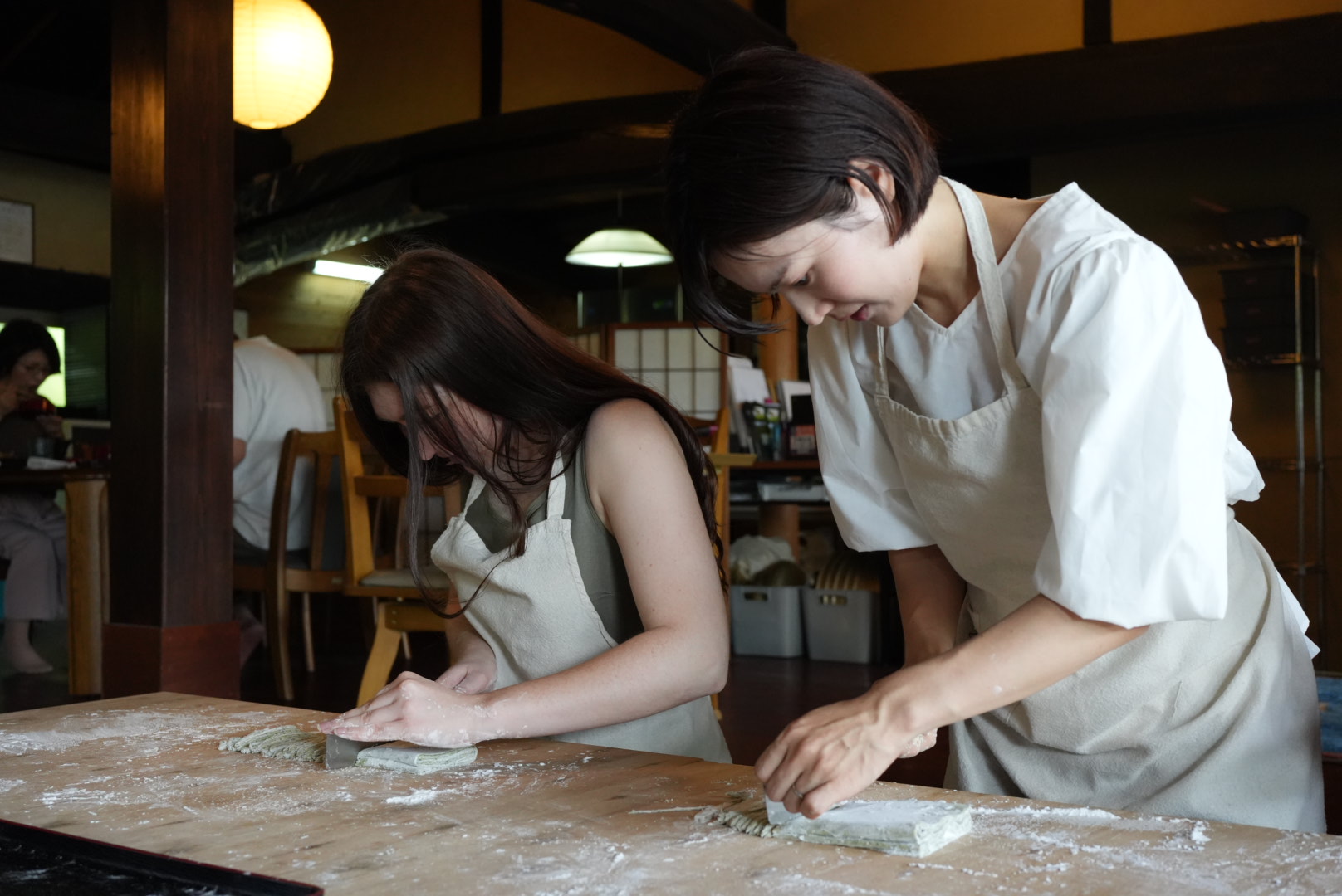 古民家で一緒に麺の生地をこねる参加者