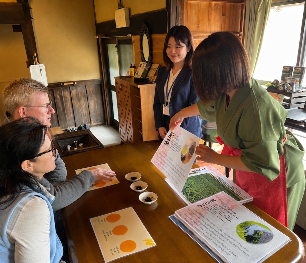 和束家でスタッフが参加者に和束茶の資料を示し、茶文化を紹介している様子